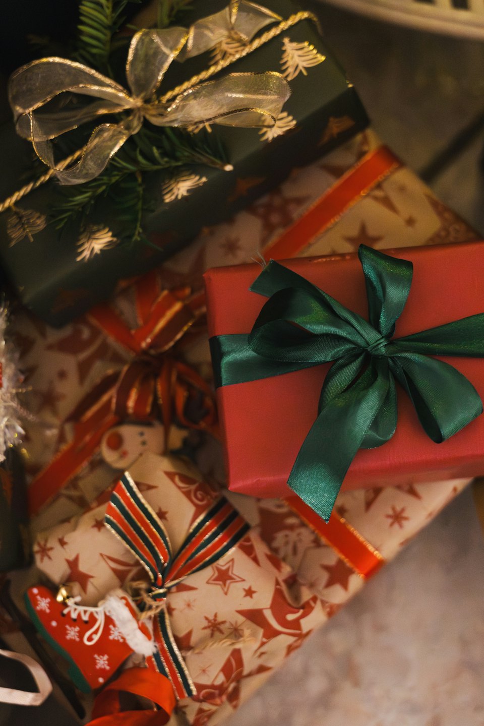 A stack of wrapped holiday gifts with festive patterns.